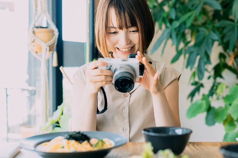 トリドリベース 料理の写真を撮る女性